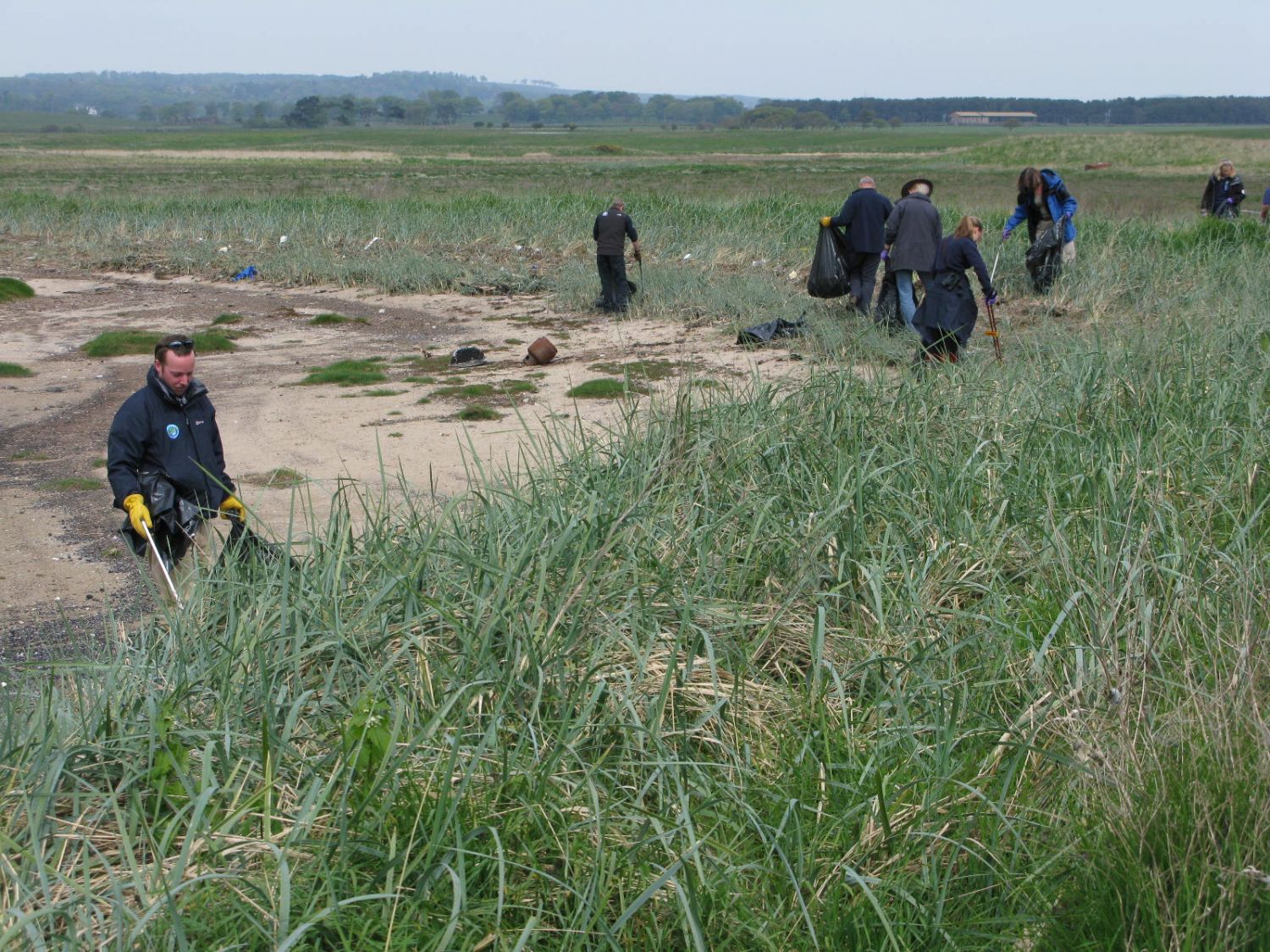 People clearing litter along a burn